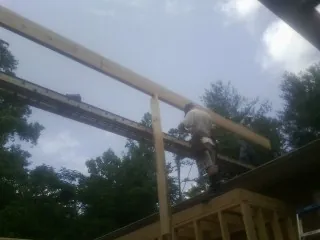 Carpenter setting a ridge beam over a new addition frame — Ice Dam Removal by Roofing Brothers in Bonners Ferry